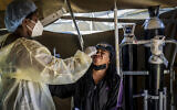 In South Africa, where the Omicron variant was first discovered, a woman is tested for COVID-19. (AP Photo/ Shiraaz Mohamed)