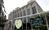 Signs hang on a fence surrounding the Tree of Life synagogue in Pittsburgh, on September 17, 2019. (AP Photo/Gene J. Puskar/File)