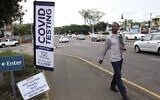 A man walks past a mobile COVID-19 testing station in Durban, South Africa, Dec.ember 3 2021. (AP Photo)