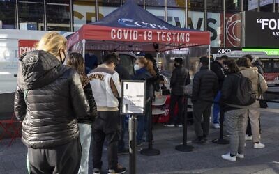 People wait in line at a COVID-19 testing site in Times Square on Friday, Dec. 3, 2021, in New York (AP Photo/Yuki Iwamura)