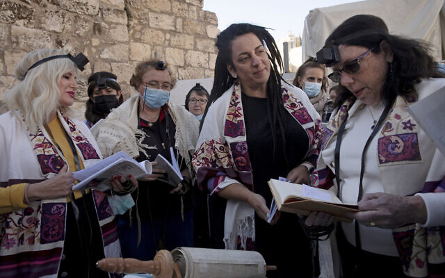 Members of Women of the Wall gather around a Torah scroll the group smuggled in for their Rosh Hodesh prayers marking the new month at the Western Wall, where women are forbidden from reading from the Torah, December 5, 2021. (AP Photo/Maya Alleruzzo) Members of Women of the Wall gather around a Torah scroll the group smuggled in for their Rosh Hodesh prayers marking the new month at the Western Wall, where women are forbidden from reading from the Torah, December 5, 2021. (AP Photo/Maya Alleruzzo)