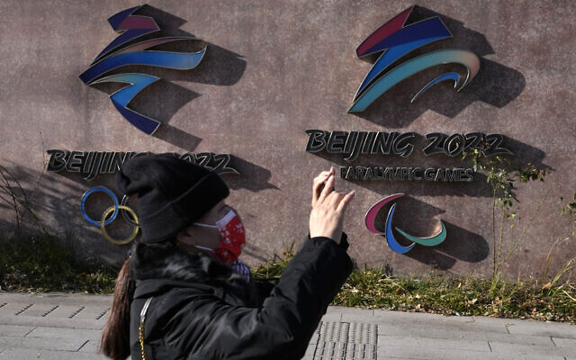 A woman wearing takes photos near the logos for the Beijing Winter Olympics and Paralympics in Beijing, China, Nov. 9, 2021 (AP Photo/Ng Han Guan) A woman wearing takes photos near the logos for the Beijing Winter Olympics and Paralympics in Beijing, China, Nov. 9, 2021 (AP Photo/Ng Han Guan)
