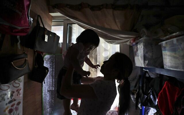 Maya, 36, plays with her one-year-old undocumented daughter in a dank, overstuffed section of an apartment, subdivided by hinged partitions, that she shares with eight other women, in Dubai, United Arab Emirates, Nov. 24, 2021. (Kamran Jebreili/AP) Maya, 36, plays with her one-year-old undocumented daughter in a dank, overstuffed section of an apartment, subdivided by hinged partitions, that she shares with eight other women, in Dubai, United Arab Emirates, Nov. 24, 2021. (Kamran Jebreili/AP)