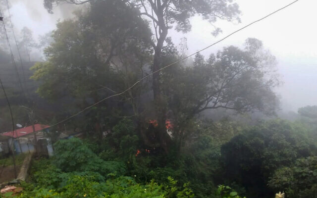 Smoke rises from fire after an army helicopter carrying India's Chief of Defense Staff Bipin Rawat crashed near Coonoor, Tamil Nadu state, India, December 8, 2021. (Bangalore New Photos via AP)