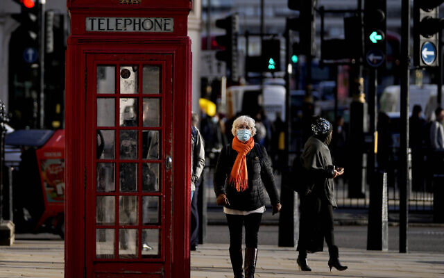 People wear face coverings as they walk through Westminster, in London, Thursday, Dec. 9, 2021. British Prime Minister Boris Johnson has announced tighter restrictions to stem the spread of the omicron variant. He is again urging people to work from home and mandating COVID-19 passes to get into nightclubs and large events. (AP Photo/Frank Augstein) People wear face coverings as they walk through Westminster, in London, Thursday, Dec. 9, 2021. British Prime Minister Boris Johnson has announced tighter restrictions to stem the spread of the omicron variant. He is again urging people to work from home and mandating COVID-19 passes to get into nightclubs and large events. (AP Photo/Frank Augstein)