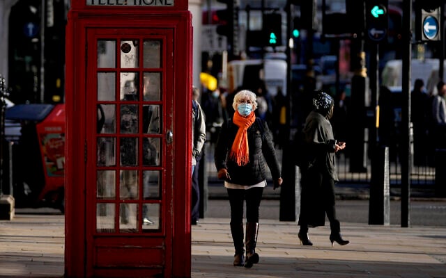 People wear face coverings as they walk through Westminster, in London, December 9, 2021. (AP Photo/Frank Augstein) People wear face coverings as they walk through Westminster, in London, December 9, 2021. (AP Photo/Frank Augstein)