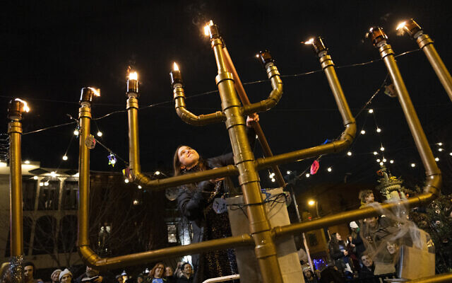 Rabbanit Dasi Fruchter, of the South Philadelphia Shtiebel, lights a menorah during a public Hanukkah celebration and menorah lighting ceremony in South Philadelphia, on Sunday, December 5, 2021. (AP Photo/Ryan Collerd) Rabbanit Dasi Fruchter, of the South Philadelphia Shtiebel, lights a menorah during a public Hanukkah celebration and menorah lighting ceremony in South Philadelphia, on Sunday, December 5, 2021. (AP Photo/Ryan Collerd)
