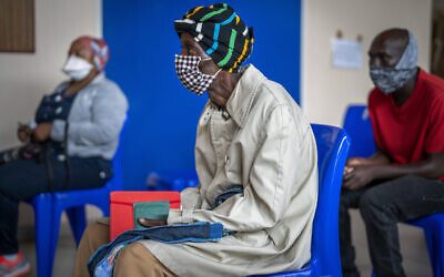 People wait for COVID-19 vaccination at Soweto's Baragwanath hospital December 13, 2021. (AP Photo/Jerome Delay)