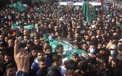 Palestinian mourners carry the bodies of two members of Hamas who were killed after gunfire erupted last Sunday during a Hamas-organized funeral in a Palestinian refugee camp, during their funeral procession in the southern port city of Sidon, Lebanon, on December 14, 2021. (AP Photo/Mohammed Zaatari)