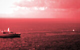 In this handout infrared photo from the US Marine Corps, the USS Portland fires a laser weapon system at a target floating in the Gulf of Aden on Tuesday, Dec. 14, 2021. (Staff Sgt. Donald Holbert/U.S. Marine Corps via AP)