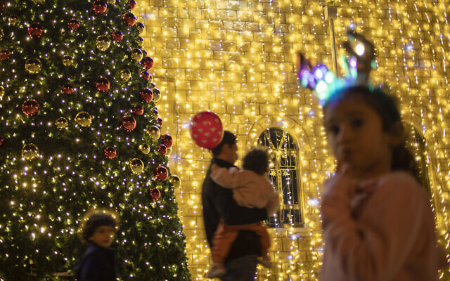 People walk past a Christmas decorated church in Haifa, Israel, Wednesday, Dec. 15, 2021. (AP/Ariel Schalit) People walk past a Christmas decorated church in Haifa, Israel, Wednesday, Dec. 15, 2021. (AP/Ariel Schalit)