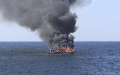 A traditional dhow sailing vessel suspected of smuggling drugs burns in the Gulf of Oman, on December 15, 2021. (US Navy via AP)