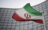 A national flag of Iran waves in front of the building of the International Atomic Energy Agency, IAEA, in Vienna, Austria, Friday, Dec. 17, 2021. (AP Photo/Michael Gruber)