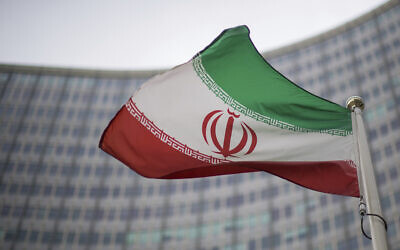 A national flag of Iran waves in front of the building of the International Atomic Energy Agency, IAEA, in Vienna, Austria, Friday, Dec. 17, 2021. (AP Photo/Michael Gruber)