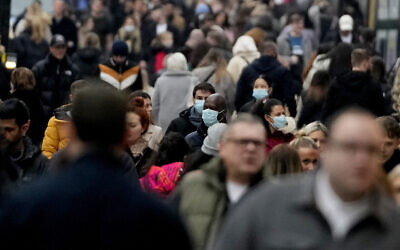 Shoppers walk along Oxford Street, Europe's busiest shopping street, in London, Dec. 18, 2021 (AP Photo/Frank Augstein)