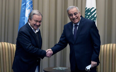 Lebanese Foreign Minister Abdallah Bouhabib, right, shakes hand with United Nations Secretary-General Antonio Guterres, upon his arrival at the Rafik Hariri International Airport in Beirut, Lebanon, December 19, 2021. (AP Photo/Hassan Ammar)