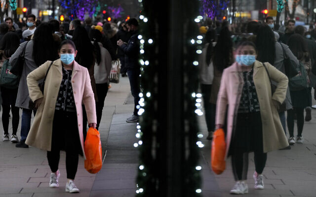 Shoppers are reflected in a window as they walk down Oxford Street in London, on December 23, 2021. (AP Photo/Frank Augstein) Shoppers are reflected in a window as they walk down Oxford Street in London, on December 23, 2021. (AP Photo/Frank Augstein)