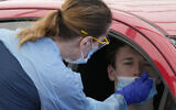 A man has a swab taken at a drive-through COVID-19 testing clinic at Bondi Beach in Sydney, December 21, 2021. (AP Photo/Rick Rycroft, File)