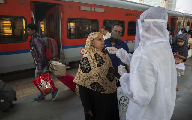 A health worker takes a swab sample of a traveler to test for COVID-19 at a train station in Mumbai, India, December 30, 2021. (AP Photo/Rafiq Maqbool) A health worker takes a swab sample of a traveler to test for COVID-19 at a train station in Mumbai, India, December 30, 2021. (AP Photo/Rafiq Maqbool)