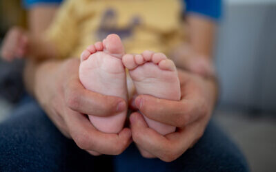 A father holds the legs of his baby girl in Jerusalem, December 30, 2020. (Shir Torem/Flash90)