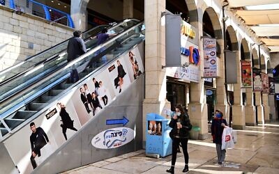 People walk in a mall in Rosh Pina, ahead of its wider reopening to the public, on March 2, 2021. (Michael Giladi/Flash90)