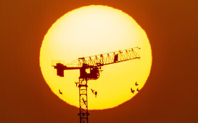 Cranes working on sunset at a construction site in Jerusalem, on September 1, 2021. (Nati Shohat/Flash90)