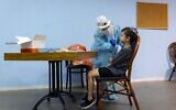 A Magen David Adom worker takes a swab sample for a COVID-19 rapid antigen test from a young boy, at a testing center in Jerusalem, on September 26, 2021. (Olivier Fitoussi/ Flash90)