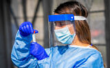 A healthcare worker collects swab samples at a COVID-19 drive-thru testing site in Modi'in, on November 10, 2021. (Yossi Aloni/Flash90)