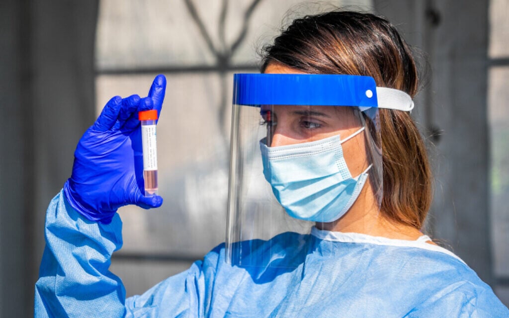 A healthcare worker at a drive testing complex in Modi'in, (Yossi Aloni/Flash90) A healthcare worker at a drive testing complex in Modi'in, (Yossi Aloni/Flash90)