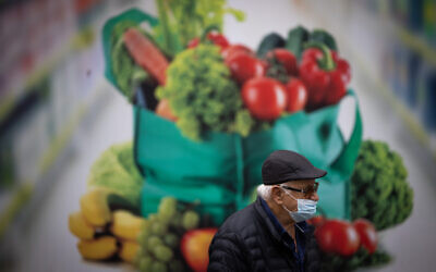 A man wearing a protective face mask walks in Jerusalem, December 2, 2021. (Yonatan Sindel/Flash90)