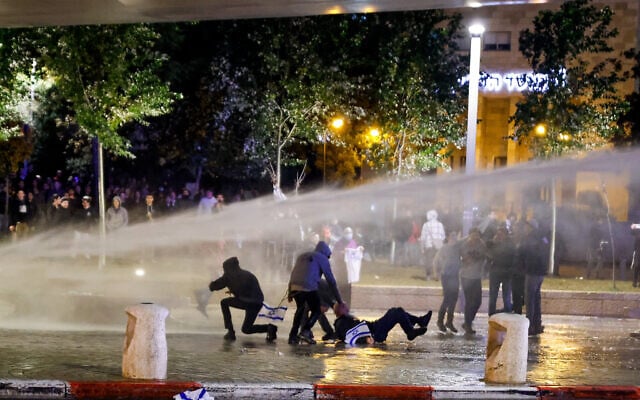 Police use a water cannon to disperse protesters in Jerusalem on Saturday, December 18, 2021. The protesters were there to urge more government action against recent deadly terror attacks. (Olivier Fitoussi/Flash90) Police use a water cannon to disperse protesters in Jerusalem on Saturday, December 18, 2021. The protesters were there to urge more government action against recent deadly terror attacks. (Olivier Fitoussi/Flash90)