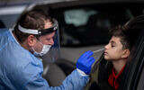 Healthcare workers take test samples on December 21, 2021 (Yonatan Sindel/Flash90)