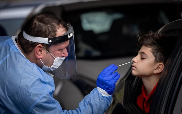 Healthcare workers take test samples on December 21, 2021 (Yonatan Sindel/Flash90) Healthcare workers take test samples on December 21, 2021 (Yonatan Sindel/Flash90)
