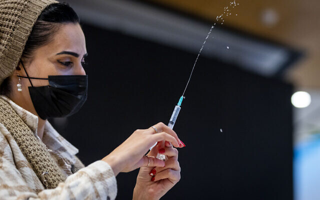 A nurse administers a dose of the coronavirus vaccine at a pop-up Health Ministry vaccine center at the Malcha mall in Jerusalem, on December 23, 2021. (Olivier Fitoussi/Flash90) A nurse administers a dose of the coronavirus vaccine at a pop-up Health Ministry vaccine center at the Malcha mall in Jerusalem, on December 23, 2021. (Olivier Fitoussi/Flash90)