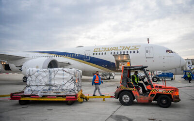 Airport workers unload packages of Pfizer’s COVID-fighting Paxlovid pill at Ben Gurion International Airport on December 30, 2021. (Avshalom Sassoni/Flash90)