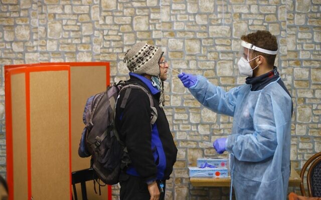 Medical staff administer COVID-19 tests at a Magen David Adom testing center in Jerusalem, on December 30, 2021. (Olivier Fitoussi/Flash90) Medical staff administer COVID-19 tests at a Magen David Adom testing center in Jerusalem, on December 30, 2021. (Olivier Fitoussi/Flash90)