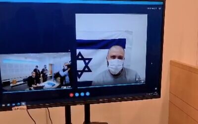 Screen capture from video of Omri Goren, accused of offering to spy on Defense Minister Benny Gantz for Iran, during a remand hearing at Lod District Court, on December 2, 2021. (Channel 12 News)