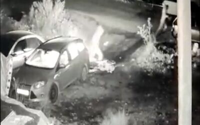 Security camera footage shows two suspects fleeing after firebombing a car owned by a Jewish resident of East Jerusalem's Sheikh Jarrah neighborhood, December 12, 2021. (Screen capture: Twitter)