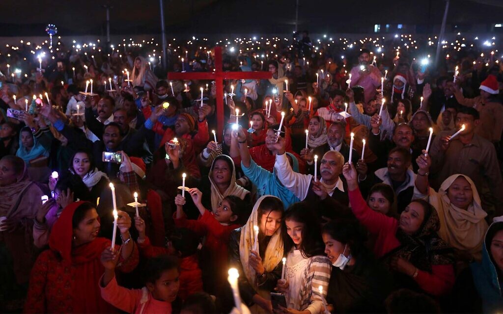 Christians hold candles during a celebration for Christmas, in Lahore, Pakistan, December 22, 2021. (AP Photo/K.M. Chaudary)