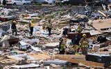 Members of the Bowling Green Fire Department dig through the remains of a house destroyed by a tornado in Bowling Green, Kentucky, Dec. 11, 2021. (AP Photo/Michael Clubb)