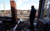 A stands near his tornado-damaged home in Mayfield, Kentucky, on December 11, 2021. (AP Photo/Mark Humphrey)