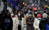 Shoppers wearing face masks walk down Oxford Street, Europe's busiest shopping street, in London, on December 23, 2021. (AP/Frank Augstein)