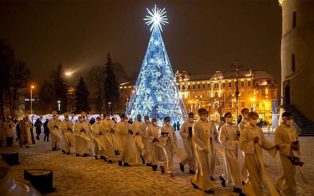 Priests and clergy walk in a procession to attend the Christmas celebration midnight Mass at the Cathedral-Basilical in Vilnius, Lithuania, December 24, 2021. (AP Photo/Mindaugas Kulbis)