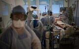 Medical workers tend to a COVID-19 patient on a ventilator in the intensive care unit at the la Timone hospital in Marseille, southern France, on December 23, 2021. (AP Photo/Daniel Cole)