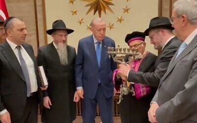 Turkish President Recep Tayyip Erdogan (center) is presented with a silver Menorah during a meeting with a delegation of Jewish leaders in Ankara, December 22, 2021 (video screenshot)