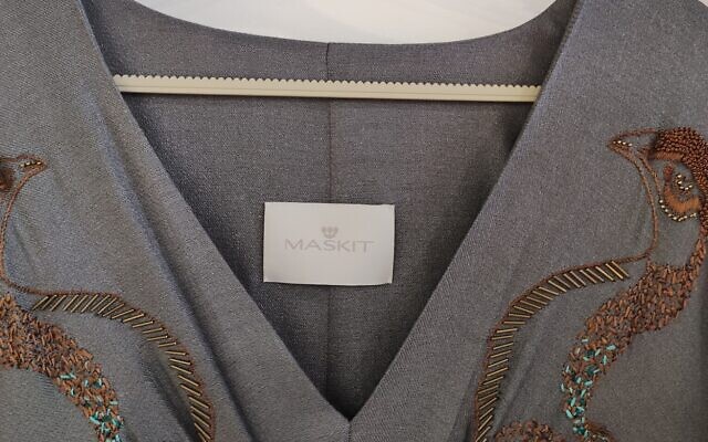 The label of the Maskit-designed, peacock-embroidered caftan worn by  Sarah Jessica Parker for the opening episode of the 'Sex in the City' reboot that premiered December 9, 2021 (Courtesy Maskit PR)