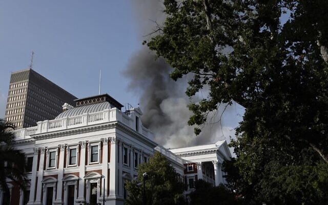 Smoke billows from the roof of a building at the South African Parliament precinct in Cape Town on January 2, 2022, during a fire incident. (Marco Longari / AFP) Smoke billows from the roof of a building at the South African Parliament precinct in Cape Town on January 2, 2022, during a fire incident. (Marco Longari / AFP)