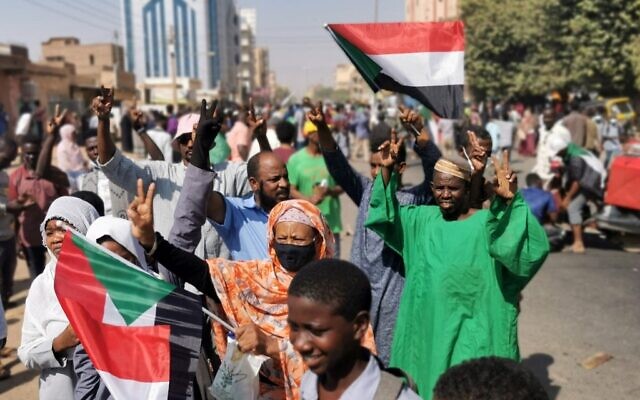 Sudanese protesters raise national flags as they protest against the October 2021 military coup, in the capital Khartoum, on January 9, 2022. (AFP) Sudanese protesters raise national flags as they protest against the October 2021 military coup, in the capital Khartoum, on January 9, 2022. (AFP)