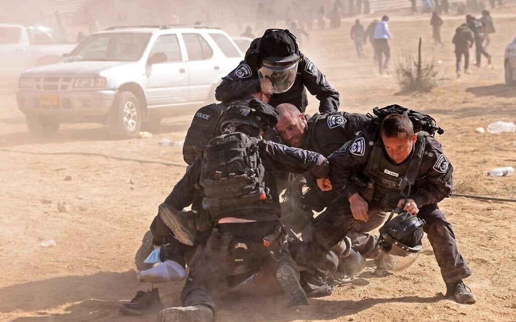 Israeli police detain a man as Bedouins protest in the southern Negev Desert against a forestation project by the Jewish National Fund (JNF), on January 12, 2022. (AHMAD GHARABLI / AFP) Israeli police detain a man as Bedouins protest in the southern Negev Desert against a forestation project by the Jewish National Fund (JNF), on January 12, 2022. (AHMAD GHARABLI / AFP)