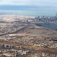 An aerial view taken on January 1, 2022 from a passenger plane shows a general view of the Gulf Emirate of Dubai with the capital of the United Arab Emirates, Abu Dhabi, in the background. (Marina Passos / AFP)